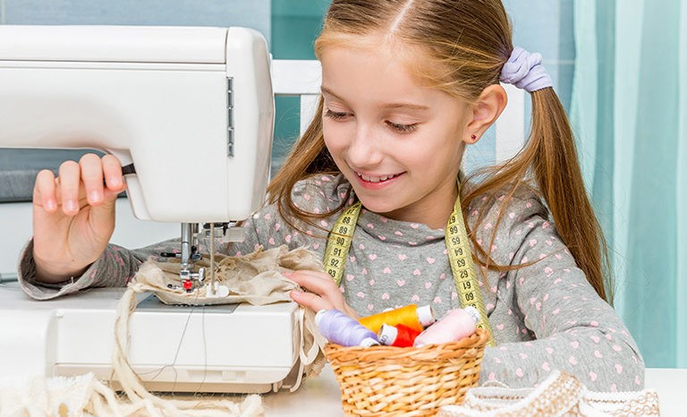 smiling little girl with sewing machine